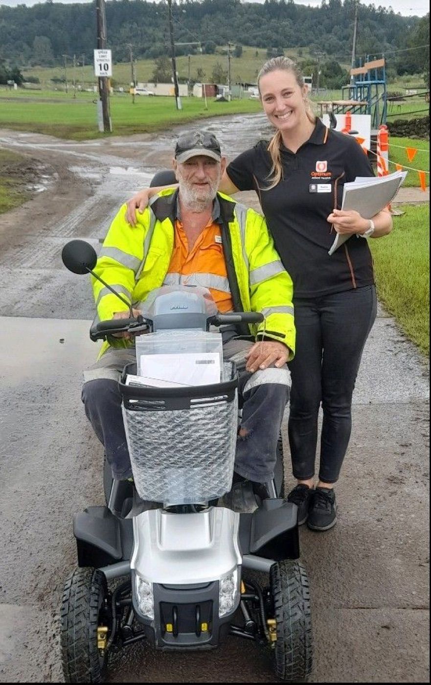 Optimum clinician with a client on his mobility scooter during a community visit