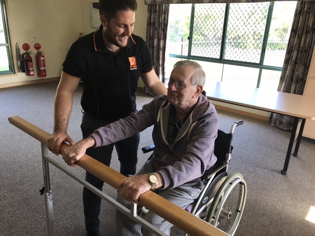 Physiotherapist supporting a client during a balance exercise