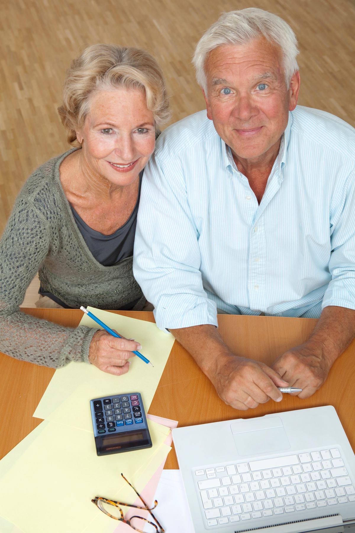 Senior couple reviewing their budget with a laptop and calculator